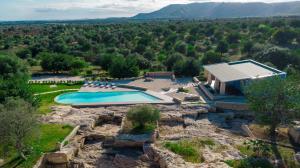 an aerial view of a house with a pool on a mountain at Le Cave di Fontane Bianche in Cassibile
