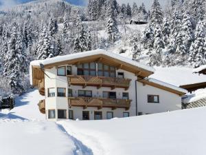 a building covered in snow with trees in the background at Apartment Marina - MHO622 by Interhome in Schwendau