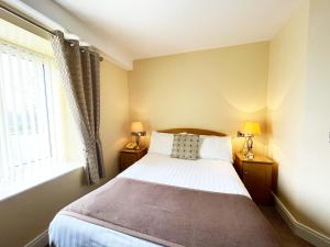 - une petite chambre avec un lit et une fenêtre dans l'établissement Óstán Loch Altan, à Cashel Hill