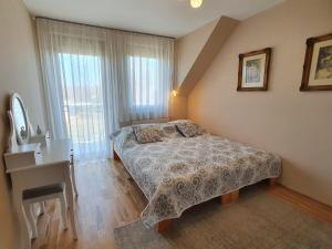 ケストヘイにあるDorci apartmanのベッドルーム1室(ベッド1台、デスク、窓付)