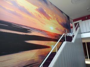 un grande dipinto della spiaggia su un muro di Appartement Kompas a Hollum