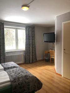 ein Hotelzimmer mit einem Bett und einem TV in der Unterkunft Hotel Jokkmokk in Jokkmokk