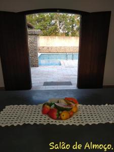une assiette de fruits sur une table avec une fenêtre dans l'établissement Chácara A Grande Família, à São Paulo