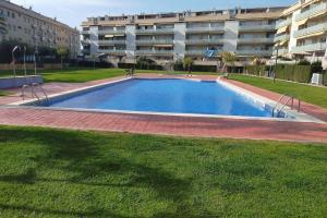 una piscina vacía frente a un edificio en Apartamento para 5 personas frente al mar con piscina y parking, en Cubelles