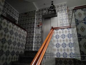 un conjunto de escaleras con una ventana y una cortina en Residencial das Trinas 2, en Guimarães