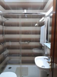 uma casa de banho com um chuveiro, um WC e um lavatório. em Residencial das Trinas 2 em Guimarães