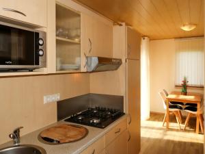 eine kleine Küche mit einem Herd und einem Tisch in der Unterkunft Holiday Home Erzeberg-1 by Interhome in Balhorn