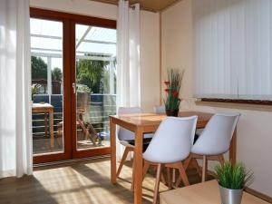 una sala da pranzo con tavolo in legno e sedie bianche di Holiday Home Erzeberg-1 by Interhome a Balhorn