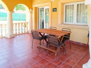 Balcon del MarにあるHoliday Home Monte Verde-1 by Interhomeの木製のテーブルと椅子が置かれたポーチ