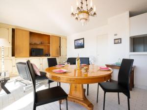 a kitchen and dining room with a wooden table and chairs at Apartment Les Marinas d'Ulysse IV by Interhome in Le Grau-du-Roi