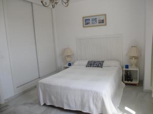 una camera con un letto bianco e due lampade di Duplex Cortijo Chico Mijas, piscina, garaje, Wifi a Málaga