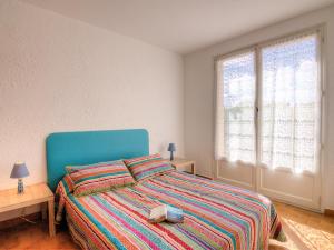 - une chambre avec un lit à tête bleue dans l'établissement Holiday Home Les Villas de l'Aygual by Interhome, à Saint Cyprien Plage