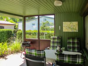 a screened porch with two chairs and a table at Holiday Home Am Walde-1 by Interhome in Dobbertin