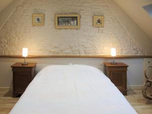 
a bedroom with a bed, lamp and a painting on the wall at Holiday Home La Salicorne - CEZ401 in Créances
