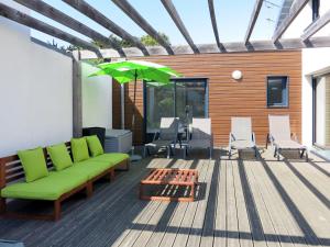 サンティレール・ド・リエにあるHoliday Home Nid Douillet - SHR170 by Interhomeのデッキ(緑のソファ、椅子、パラソル付)