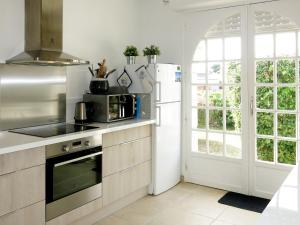 a kitchen with a refrigerator and a microwave at Holiday Home Pen Er Guer - RHU362 by Interhome in Saint-Gildas-de-Rhuys