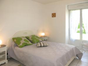 ein weißes Schlafzimmer mit einem Bett und einem Fenster in der Unterkunft Holiday Home Le Petit Maître - LET300 by Interhome in Le Tronchet