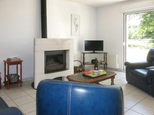 ein Wohnzimmer mit einem Sofa und einem Kamin in der Unterkunft Holiday Home Le Petit Maître - LET300 by Interhome in Le Tronchet