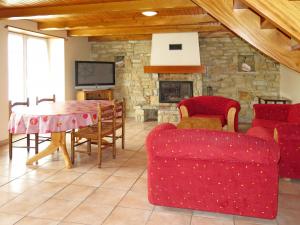 Telgruc-sur-MerにあるHoliday Home Trez Bellec - TGM101 by Interhomeの赤い家具と石造りの暖炉付きのリビングルーム