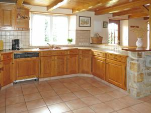 Telgruc-sur-MerにあるHoliday Home Trez Bellec - TGM101 by Interhomeのタイルフロアの広いキッチン(木製キャビネット付)