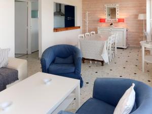 PlozévetにあるHoliday Home Rendez-vous à la plage - PZV101 by Interhomeのリビングルーム(青い椅子、テーブル付)