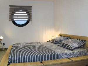 ein Bett mit zwei Kissen und ein Fenster in einem Zimmer in der Unterkunft Holiday Home Pirou Beach by Interhome in Pirou