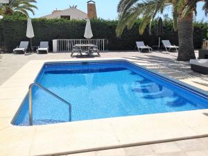 a large swimming pool with chairs and a table at Holiday Home Ki - ATE248 by Interhome in La Nucía