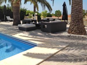 a pool with couches and chairs next to palm trees at Holiday Home Ki - ATE248 by Interhome in La Nucía