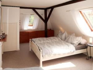 1 Schlafzimmer mit einem weißen Bett und 2 Fenstern in der Unterkunft Apartment Huuske am Polder by Interhome in Ditzumerhammrich