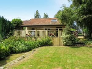 une maison avec une clôture en bois et une cour dans l'établissement Holiday Home de Beaumont - NCA400 by Interhome, à Carentan