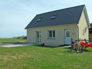 a house with a dog sitting in front of it at Holiday Home Chez Lilo by Interhome in Saint-Laurent-sur-Mer