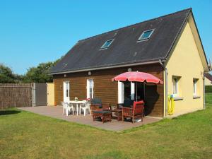 Cette maison dispose d'une terrasse avec une table et des chaises. dans l'établissement Holiday Home Chez Laurette - SNT401 by Interhome, à Saint-Laurent-sur-Mer