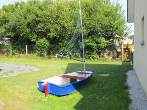 un petit bateau assis sur l'herbe dans une cour dans l'établissement Holiday Home Chez Laurette - SNT401 by Interhome, à Saint-Laurent-sur-Mer