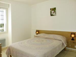 プランゲヌアルにあるApartment Les Cormorans - PGX303 by Interhomeのベッドルーム1室(ベッド1台、ランプ2つ、窓付)