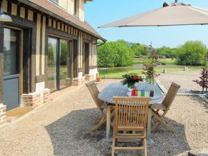 patio con tavolo, sedie e ombrellone di Holiday Home L'Etang - CRB402 by Interhome a Corbon