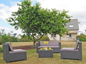 3 Stühle und eine Couch im Garten mit einem Baum in der Unterkunft Holiday Home de la Plage by Interhome in Pleubian