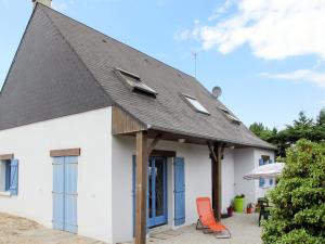 Casa blanca con techo negro y silla roja en Holiday Home Les Mouettes by Interhome, en Hauteville-sur-Mer