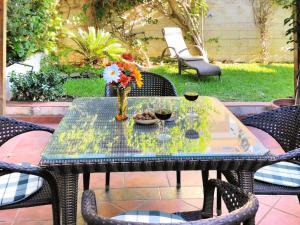 una mesa con un jarrón de flores y copas de vino en Holiday Home Playa del Conde by Interhome en Chilches