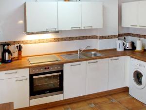 cocina con armarios blancos, fregadero y lavavajillas en Holiday Home Playa del Conde by Interhome en Chilches
