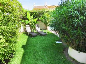 ogród z krzesłami, roślinami i trawą w obiekcie Holiday Home Playa del Conde by Interhome w mieście Chilches