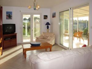 a living room with a white couch and a table at Holiday Home Kerguntuil - PBU311 by Interhome in Pleumeur-Bodou