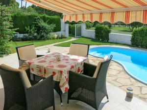 a table and chairs next to a swimming pool at Holiday Home Ingeborg by Interhome in Vilafortuny