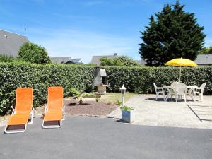 Un patio con una mesa y sillas y una sombrilla. en Holiday Home Côte des îles by Interhome, en Portbail