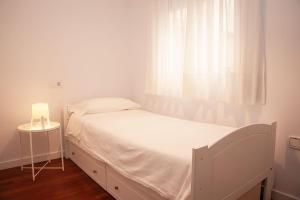 białe łóżko w pokoju z oknem w obiekcie San Policarpo w mieście Torrevieja