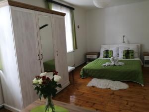 Un dormitorio con una cama verde y un jarrón de flores en Apartment Patrick, en Harrachov