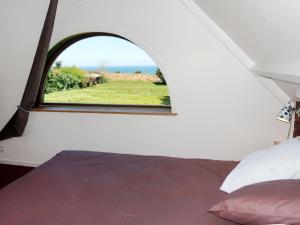 una camera da letto con finestra affacciata su un campo di Chalet L'Atelier - LOQ217 by Interhome a Locquirec