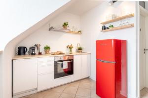 a kitchen with a red refrigerator and white cabinets at Design Apartment Zentral & Rooms - Toplage am Opernhaus in Nürnberg
