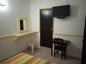 a room with a desk and a door and a chair at Hotel Kiko in Mazatlán
