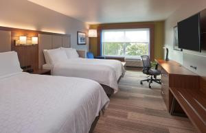 a hotel room with two beds and a flat screen tv at Holiday Inn Express Doral Miami, an IHG Hotel in Doral