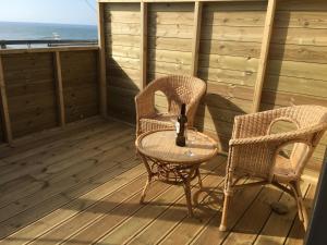 two wicker chairs and a table on a porch at Angels Corner, Ventnor Bay in Ventnor